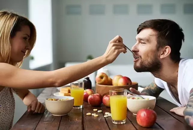 Woman feeds man nuts to enhance sexual performance
